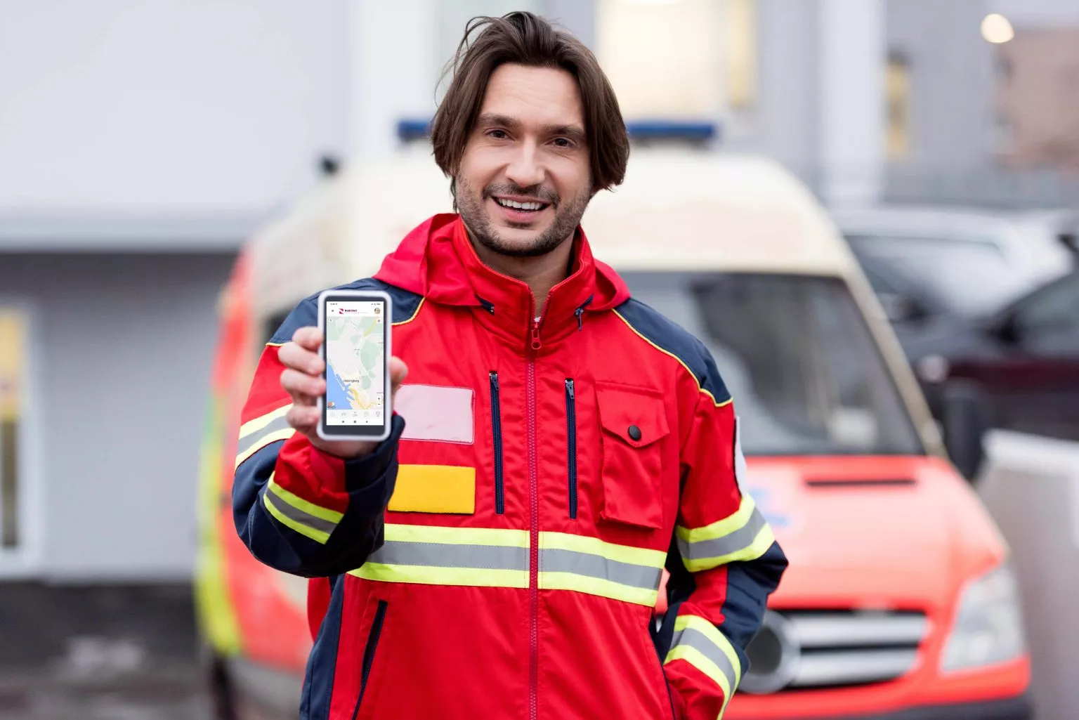 smiling-paramedic-in-red-uniform-holding-smartphon-2022-12-10-01-16-22-utc-1536x1025
